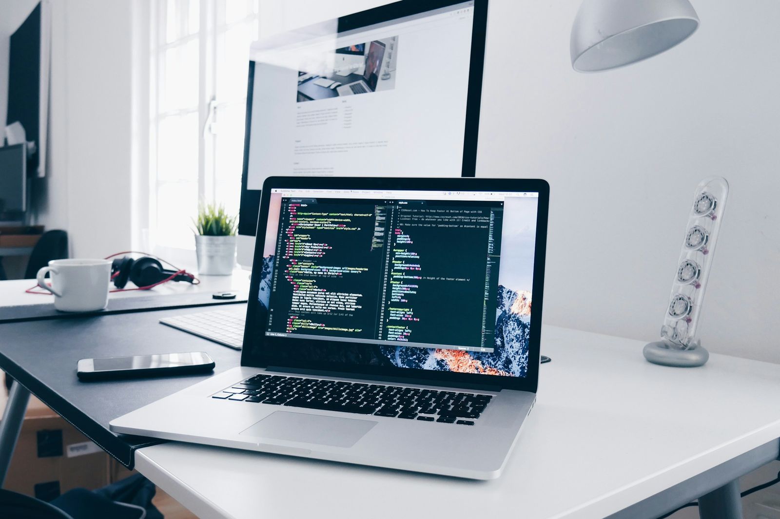 A laptop open on a tidy desk in a bright office